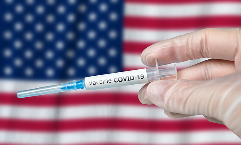Seringue vaccin contre la Covid-19 et drapeau américain